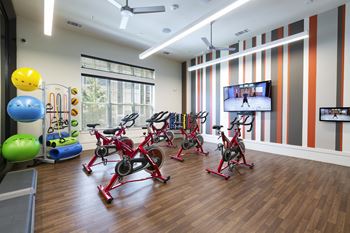A fitness room with exercise equipment and a tv